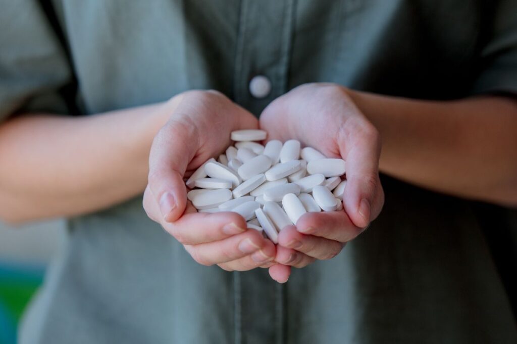 Woman holding white pills